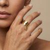 Bague Rosella. Avec son anneau doré lisse et large. Breloque en forme de plume