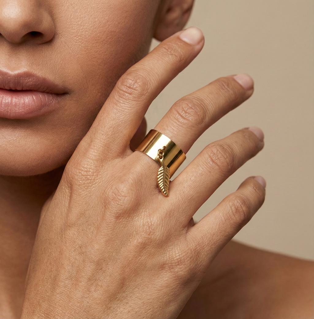 Bague Rosella. Avec son anneau doré lisse et large. Breloque en forme de plume