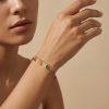 Bracelet Fabienne. Conçu en acier inoxydable doré, il est délicatement orné de petites pierres multicolores