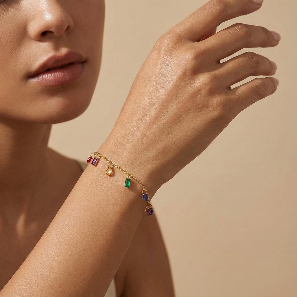 Bracelet Fabienne. Conçu en acier inoxydable doré, il est délicatement orné de petites pierres multicolores