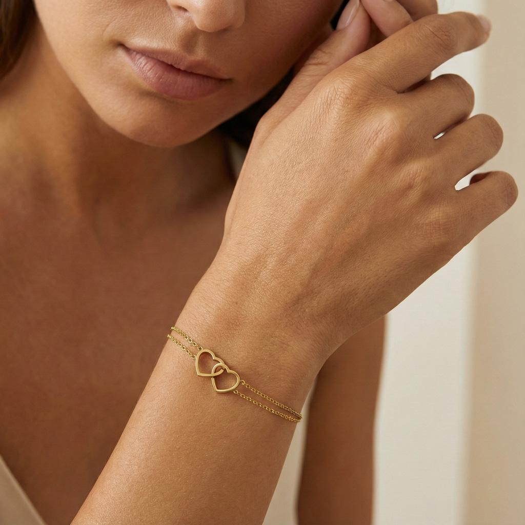 Bracelet Juliette. Confectionné en acier inoxydable doré bijou délicat orné de deux cœurs entrelacés